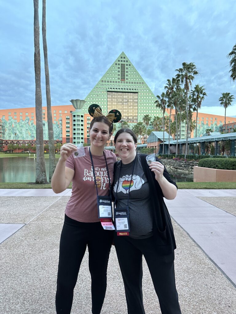 Two participants from the OLC Accelerate 2024 5K stand together and smile, showing off their awards.