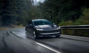 tesla model 3 driving on a wet road